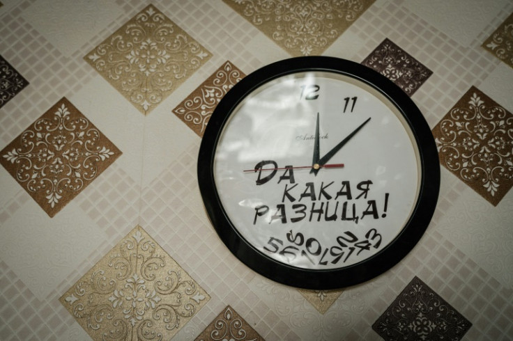 A clock whose hands move anti-clockwise with a message in Russian meaning "what's the difference!" hangs in the home of Victoria Shypko in Yampil, eastern Ukraine