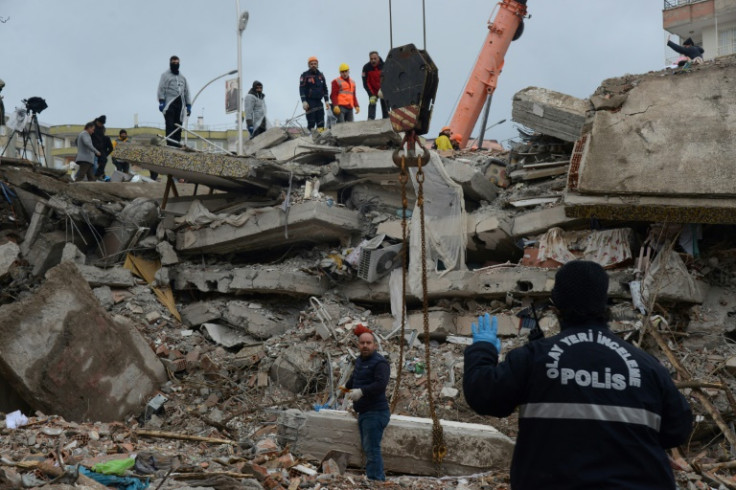 Rescuers take periodic pauses and listen for signs of life from those buried under the rubble