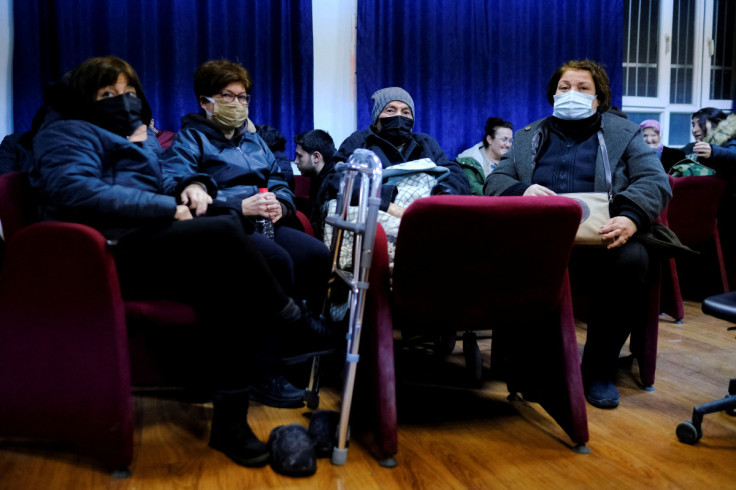 Three sisters sit around their father, Kemal Mengelogle, in a school-turned-shelter in Adana, Turkey