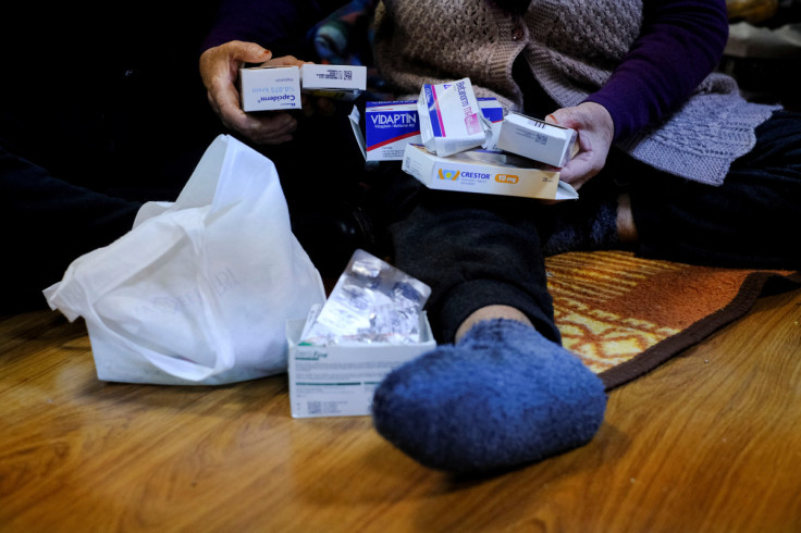 People displaced by the earthquake hold medication in a school-turned-shelter in Adana, Turkey