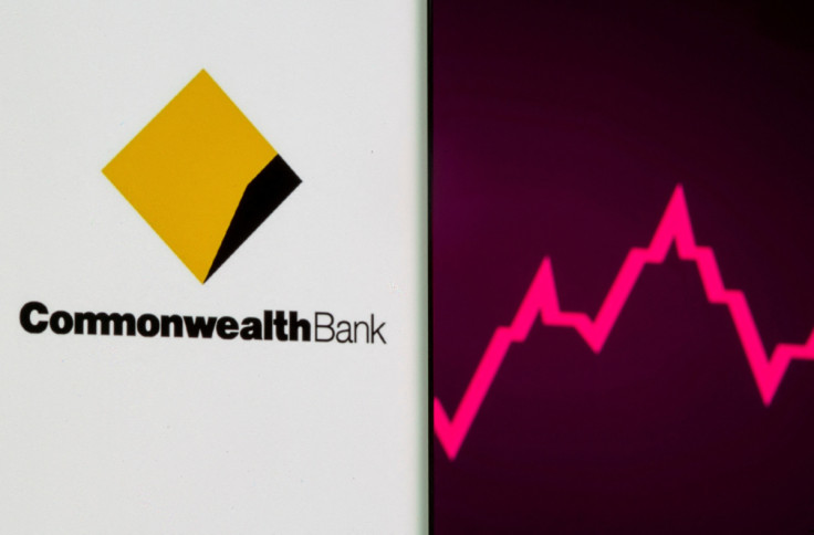 Commonwealth Bank logo is seen on a smartphone in front of a stock graph