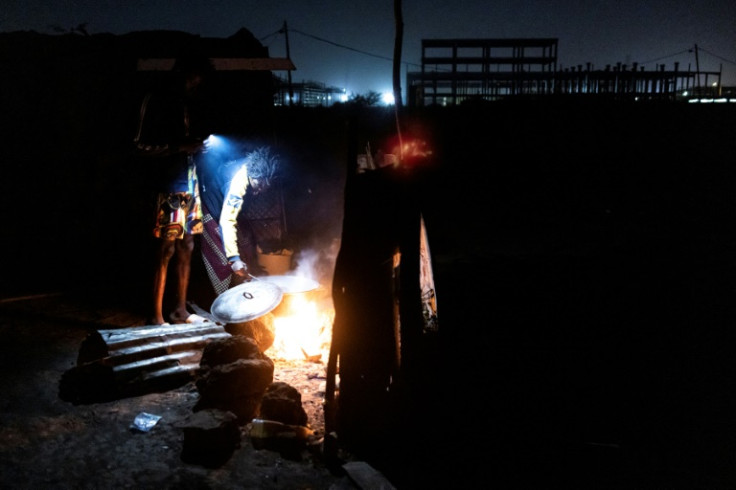 A woman cooks porridge in the early morning for construction workers in Diamniadio. This work is often done by wives who have accompanied their husbands to Senegal