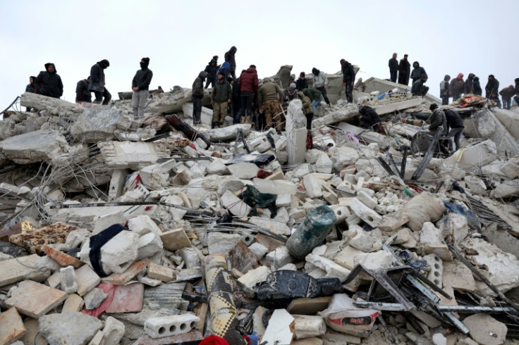 Residents and rescuers search the rubble of quake-hit buildings in Besnaya
