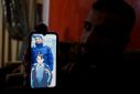 A relative of a Palestinian man, Abdel-Karim Abu Jalhoum, who died with his family in the earthquake in Turkey, shows his picture on a phone, in Beit Lahiya in northern Gaza Strip