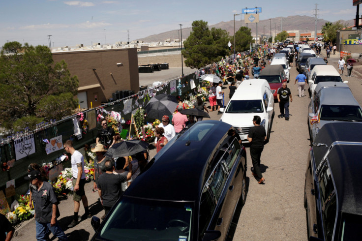 People gather during a tribute to the victims of a mass shooting at a Walmart store, in the growing memorial in El Paso