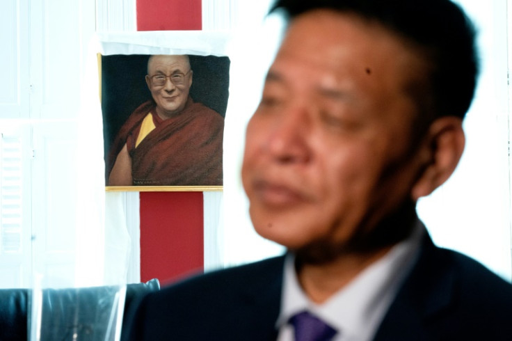 An image of the Dalai Lama is displayed behind Penpa Tsering, the political leader of Tibetans in exile