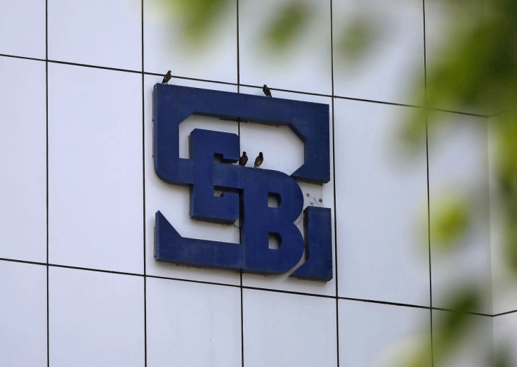 Birds rest on the logo of SEBI installed on the facade of its head office building in Mumbai