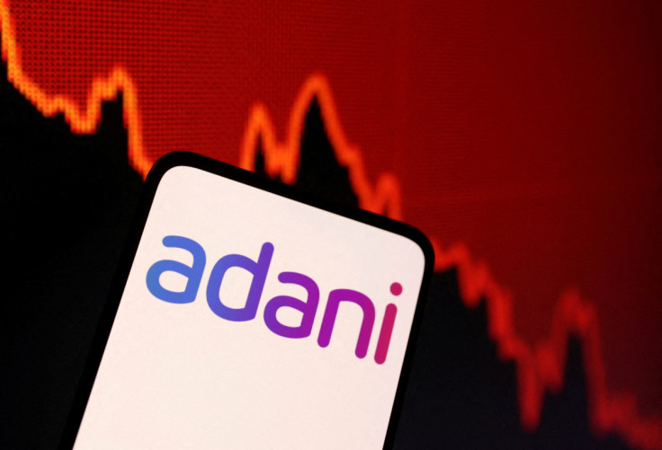 Illustration shows Adani logo and decreasing stock graph