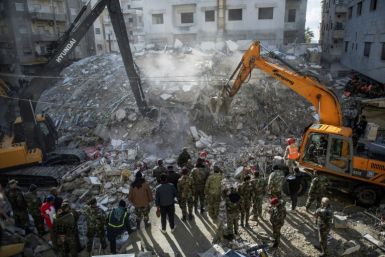 Rescue workers search for survivors in the rubble of a collapsed building in the earthquake-hit Syrian coastal city of Jableh