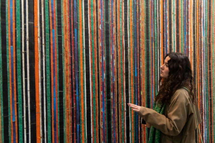 A woman looks at artwork by Algerian-born French artist Adel Abdessemed at the Zona Maco fair in Mexico City