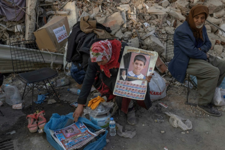 A woman holds photos of her missing grandchildren Hatay, Turkey