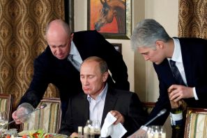 Evgeny Prigozhin assists Russian Prime Minister Vladimir Putin during a dinner with foreign scholars and journalists at the restaurant Cheval Blanc on the premises of an equestrian complex outside Moscow