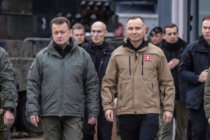 Polish Defence Minister Mariusz Blaszczak (L) and Polish President Andrzej Duda arrive for a meeting with instructors who are training Ukrainian soldiers on Leopard 2 tanks