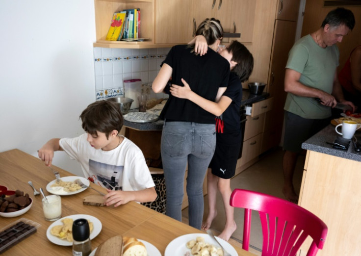 Danylo Titkov gives his mother Irina a kiss as the Ukrainian family prepare their sons for school in Vienna