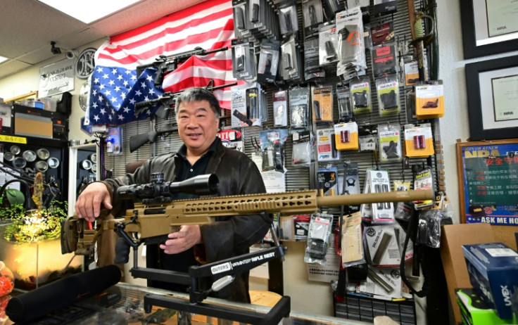 Gun seller David Liu proudly displays the weapons he has for sale