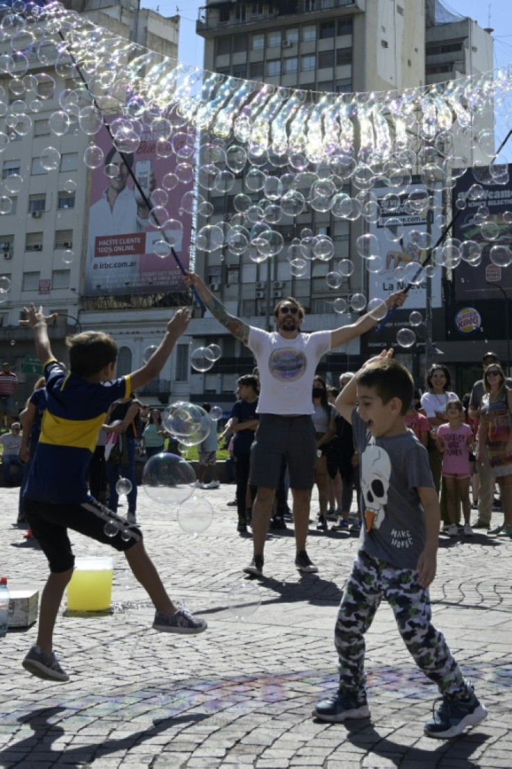 Kids play with bubbles at Republica square in Buenos Aires, in March 2022