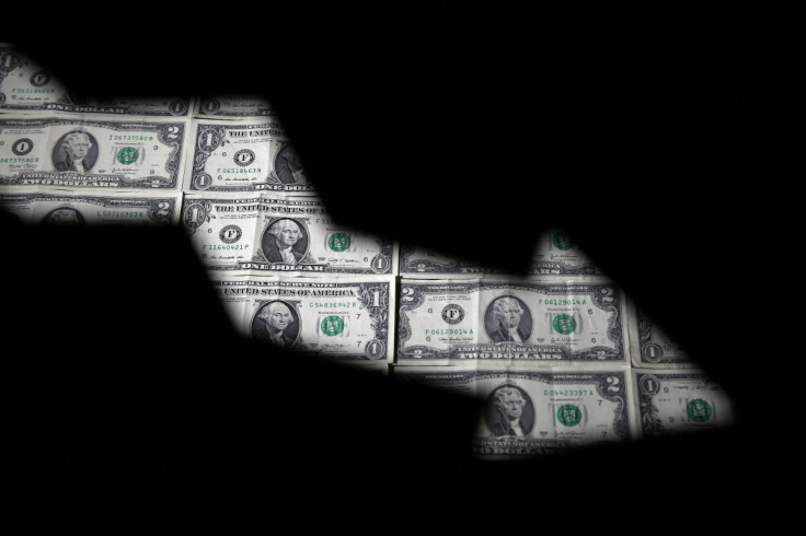 Dollar banknotes are seen through printed stock graph in this illustration