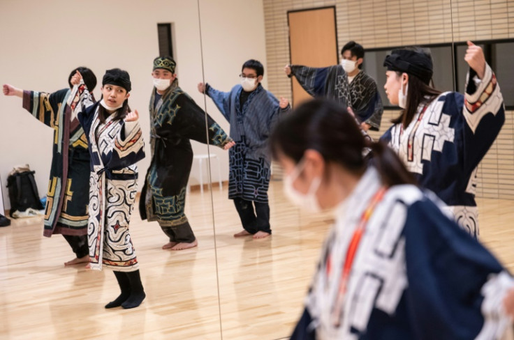 Indigenous student Mizuki Orita (2nd L) practices a traditional dance with members of the Ainu culture club Sapporo University