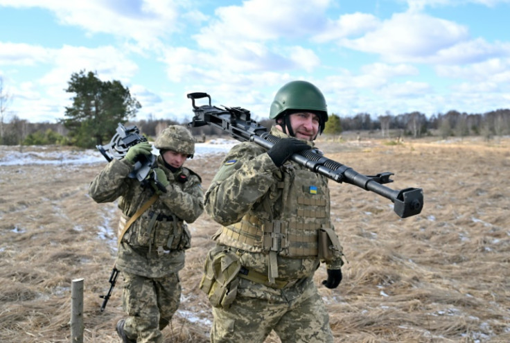 Ukrainian soldiers carry a heavy machine gun as they train near the Chernnobyl exclusion zone