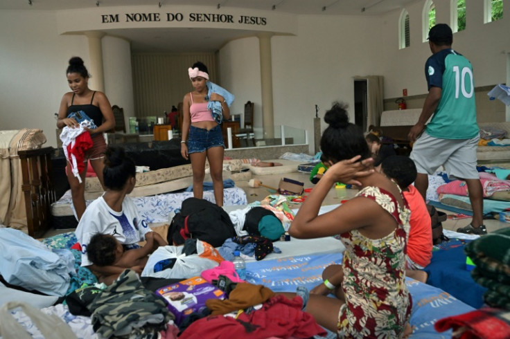 Locals take shelter at a church where donations are collected after torrential rain caused flooding and landslides at the Juquehy district in Sao Sebastiao, Sao Paulo state, Brazil, on February 20, 2023