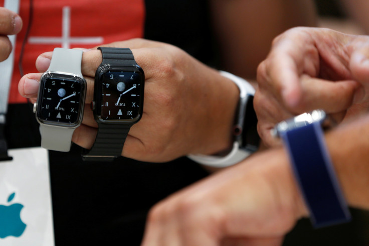 An attendee holds two titanium Apple Watch Edition smart watches in the demonstration area during a launch event at their headquarters in Cupertino