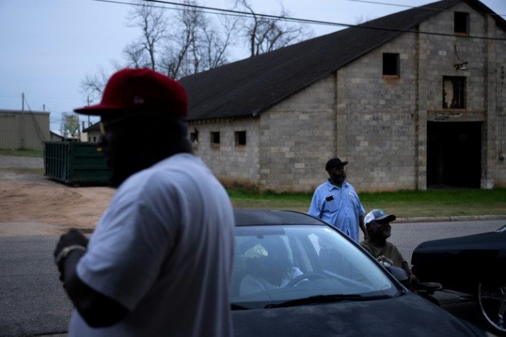 Kelvin Sims (L) talks with others outside the Dollar General in Plains, Georgia