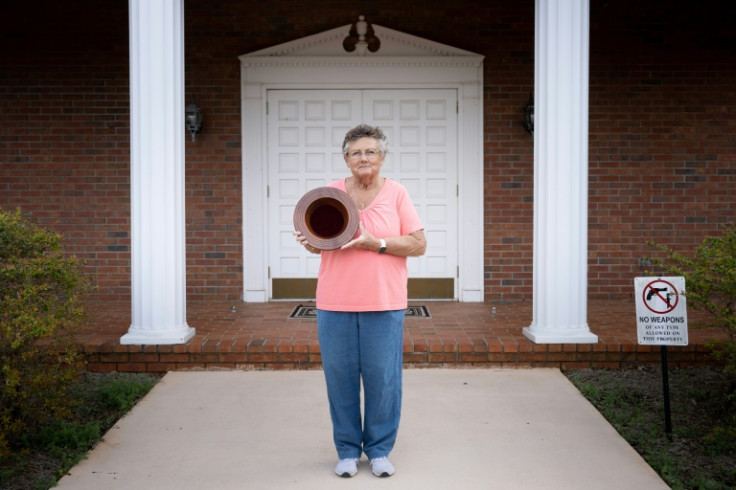 Jan Williams poses with a collection plate made by former US president Jimmy Carter, in front of Maranatha Baptist Church in Plains, Georgia on February 21, 2023