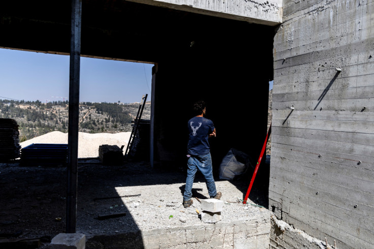 A construction worker walks through a building site in the Jewish settlement of Givat Harel in the Israeli-occupied West Bank