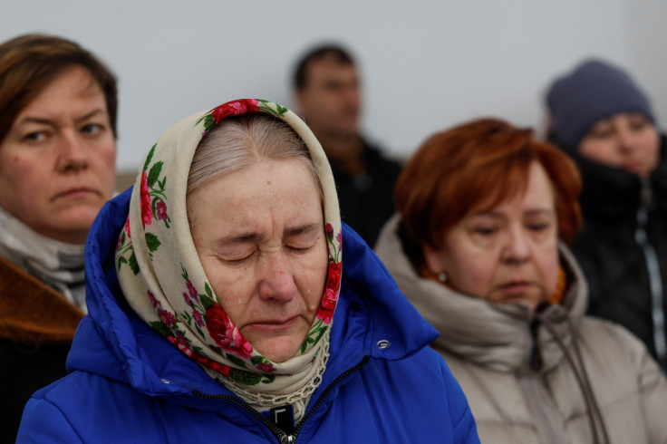 People attend a memorial service on a day of the first anniversary of Russia's attack on Ukraine, at a site of a mass grave in Bucha