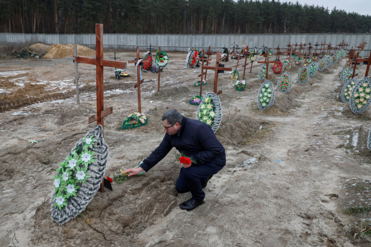 People visit graves of unidentified people, on a day of the first anniversary of Russia's attack on Ukraine, in Bucha
