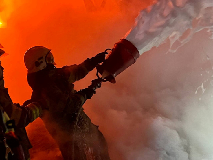 Firefighters work to put out a fire at energy infrastructure facilities, damaged by a Russian missile strike in Kyiv region