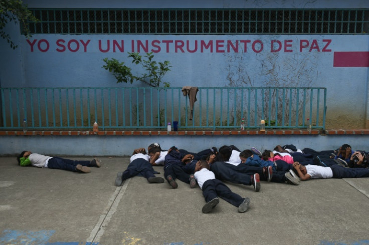 The children practice hiding under an inscription that reads: 'I am an instrument of peace'