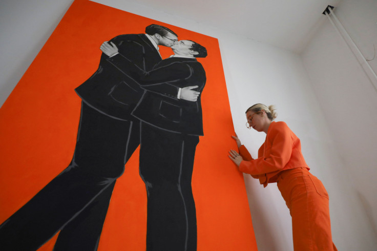 Kosovo artists Ermira Murati stands near her paiting of Kosovo Prime Minister Kurti and Serbian President Vucic