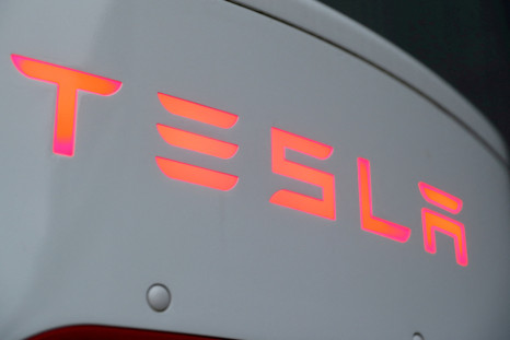 The logo of Tesla is seen at a Tesla Supercharger station