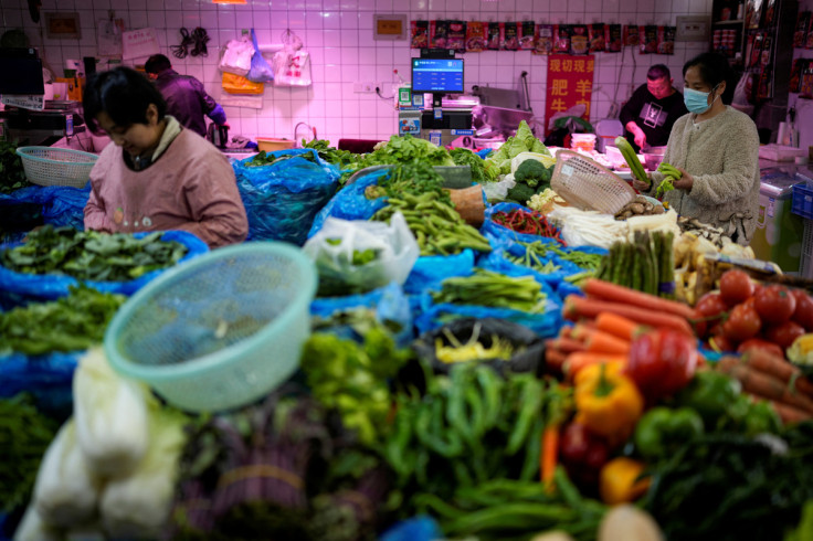 A woman chooses vegetables at a market ahead of the National People's Congress (NPC), in Shanghai