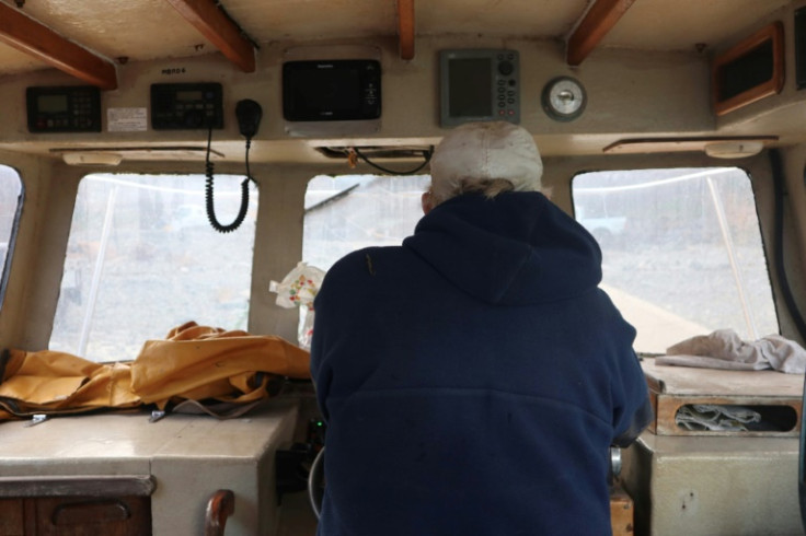 Ernest Evans takes the wheel as his son Colin brings in the boat