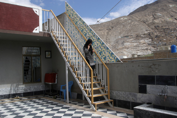 A relative of Raza walks down flight of stairs at her family home in Quetta