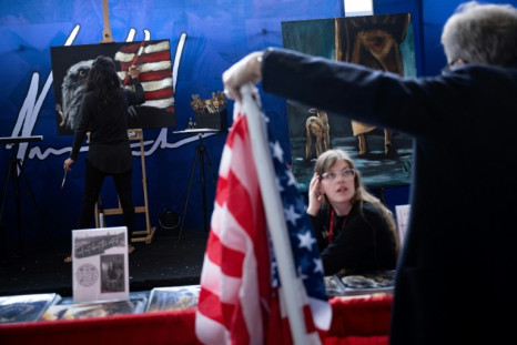 A woman paints an American flag next to an eagle, another patriotic symbol of the United States, at the CPAC gathering outside the capital Washington
