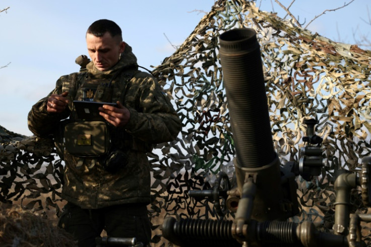 Seorang tentara Ukraina bersiap untuk menembakkan mortir Prancis ke arah posisi Rusia di garis depan di wilayah Donetsk