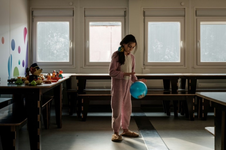 Diana, 9, plays with a ball in temporary housing for displaced people from Demydiv