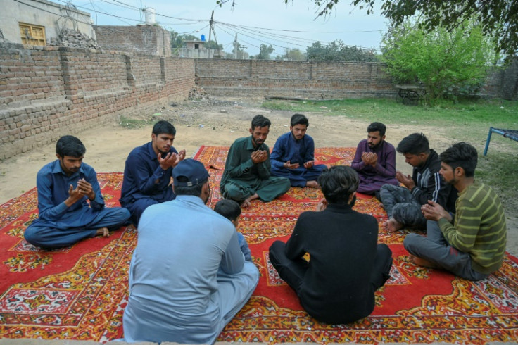 Mourners pray for Muhammad Nadeem, near his house in Gujrat district