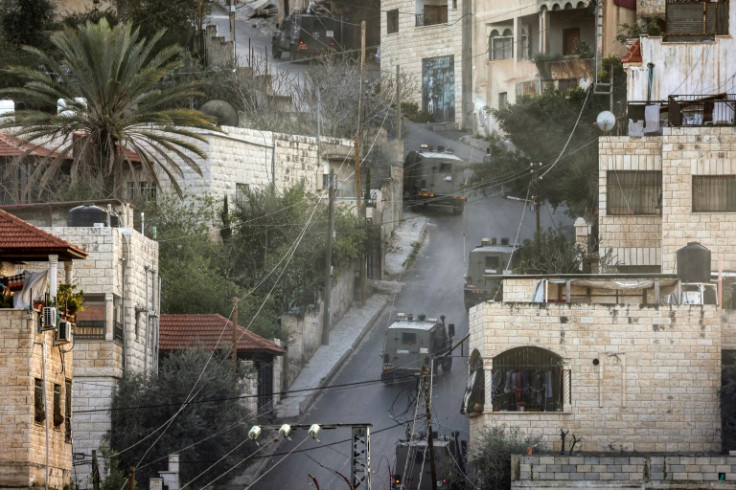 Israeli army vehicles move along a road during a raid in the Jenin camp for Palestinian refugees in the occupied West Bank