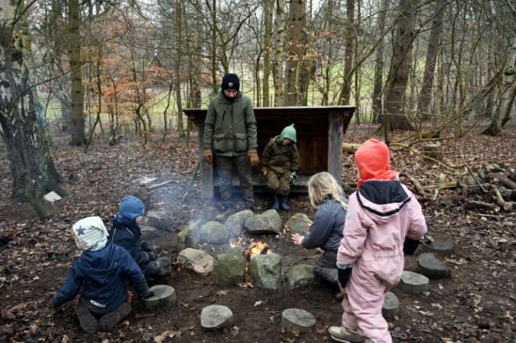 Danish preschoolers gather round a campfire at one of their outdoor classes