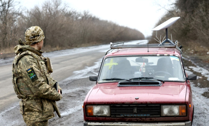 A Ukrainian serviceman stands next to a vehicle that carries a Starlink satellite internet system near the frontline