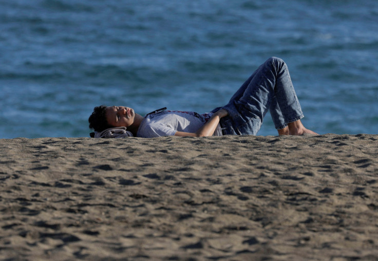 A man enjoys the sun in front of the sea during unseasonably warm temperatures in Malaga