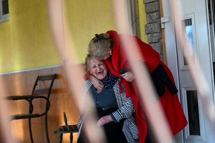 Two elderly women share a joke at a Roma-run refugee shelter in western Ukraine