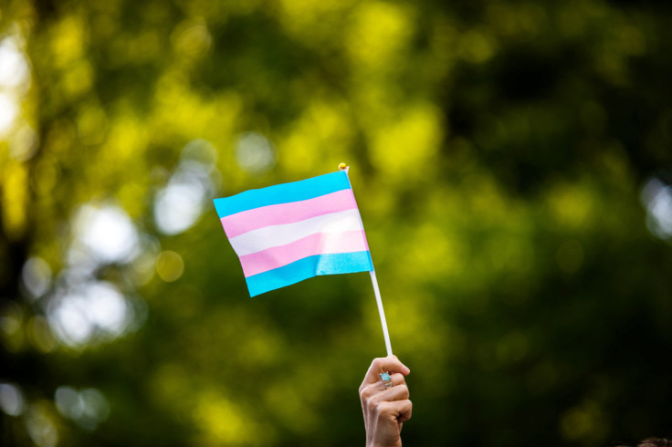 Transgender rights activist waves a transgender flag as they protest the killings of transgender women this year, at a rally in Washington Square Park