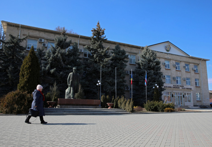 A woman walks past a monument to Soviet state founder Vladimir Lenin in Comrat