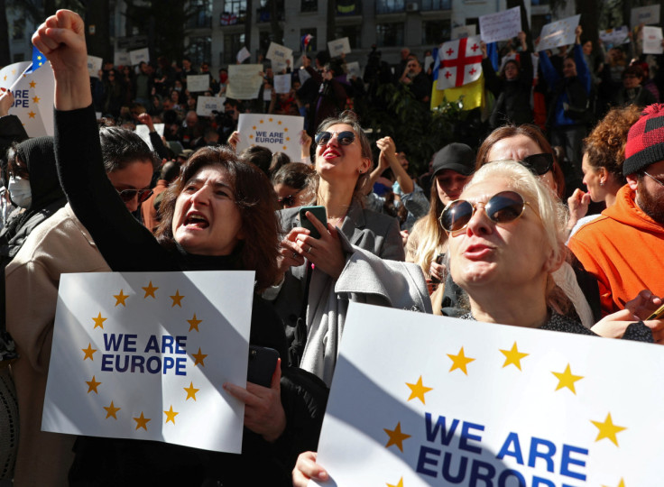 People take part in a rally outside a parliament building in Tbilisi