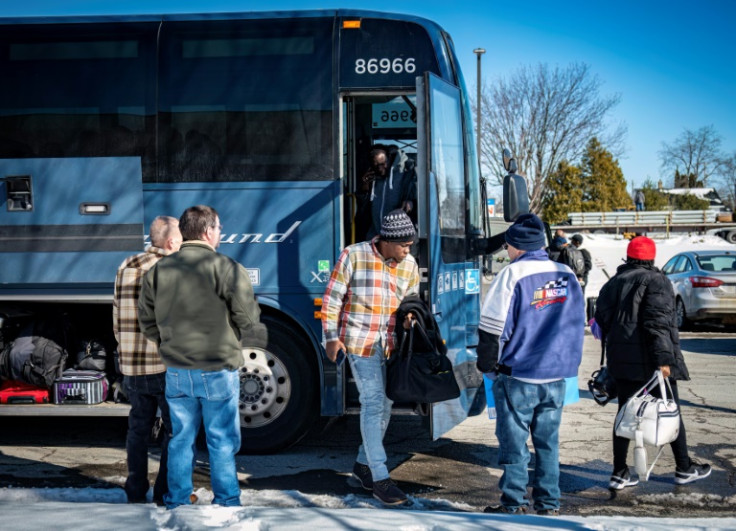 Migrants exit a bus in Plattsburgh, New York, on March 3, 2023, where taxi drivers wait to take them to the Canadian border